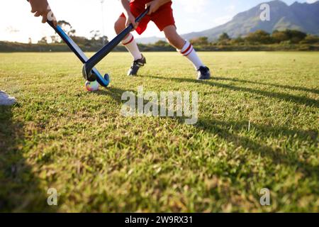 Kinder, Ball und Hockey spielen auf dem Spielfeld, für Sport oder Outdoor-Matches zusammen. Team, Kinder oder Spieler im Wettkampf auf grünem Gras für das Tackle Stockfoto