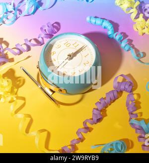 Die Uhr schlägt Mitternacht und Party-Streamer im Silvester Countdown auf einem traumhaften Hintergrund mit Pastel-Gradient Stockfoto