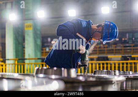 (231230) -- MA'ANSHAN, 30. Dezember 2023 (Xinhua) -- ein Mitarbeiter schleift ein Rad in einer Werkstatt in China Baowu Group Masteel Rail Transit Materials Technology Co., Ltd (MRT) in Ma'anshan, ostchinesische Provinz Anhui, 15. Dezember 2023. Die Herstellung von Rädern für Hochgeschwindigkeitszüge ist bekannt für ihre Schwierigkeit und den hohen Qualitätsanspruch. In den letzten Jahren hat Masteel aus China Baowu Group Technologien zur Herstellung von Rädern und Achsen mit unabhängigen geistigen Eigentumsrechten entwickelt und damit das langjährige Produktionsmonopol ausländischer Unternehmen gebrochen. Heute dauert es in Masteel nur etwa 68 Sekunden Stockfoto