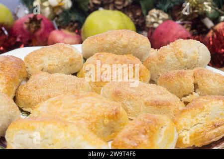 Ein festliches und appetitliches hausgemachtes Mandel-Marzipans auf einem Porzellanteller, umgeben von Weihnachtsdekorationen, die ihm einen Hauch von Süße und Fröhlichkeit verleihen. Stockfoto