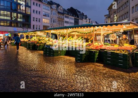 Bonn, Deutschland - 23. Dezember 2023 : Blick auf einen Freiluftmarkt mit frischem Obst und Gemüse auf dem Bonner Marktplatz in der Abenddämmerung Stockfoto