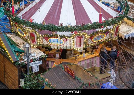 Bonn, Deutschland - 23. Dezember 2023 : Blick auf eine beleuchtete und überfüllte Weihnachtsbar mit Glühwein, dem Glühwein auf dem Bonner Weihnachtsmarkt Stockfoto