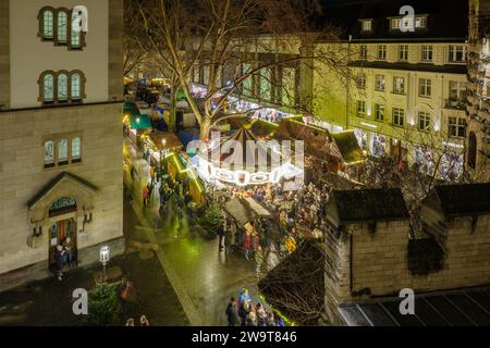 Bonn, Deutschland - 23. Dezember 2023 : Blick auf eine beleuchtete und überfüllte Weihnachtsbar mit Glühwein, dem Glühwein auf dem Bonner Weihnachtsmarkt Stockfoto