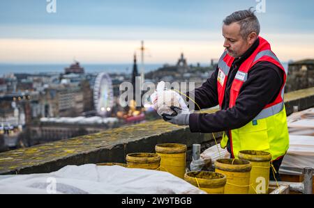 Edinburgh Castle, Edinburgh, Schottland, Vereinigtes Königreich, 30. Dezember 2023, Edinburgh Hogmanay: Revellers feiern 2024 mit Unterhaltung im gesamten Stadtzentrum. Die pyrotechnischen Zauberer Titanium entwerfen und bereiten sich erneut auf eines der weltweit besten Neujahrsfeuerwerke vor, die von den Stadtmauern von Edinburgh Castle aus gestartet werden. Die Hogmanay-Veranstaltung feiert ihr 30. Jahr. Crew-Mitglied Steve überprüft einige der Feuerwerkrohre. Credit Sally Anderson/Alamy Live News Stockfoto