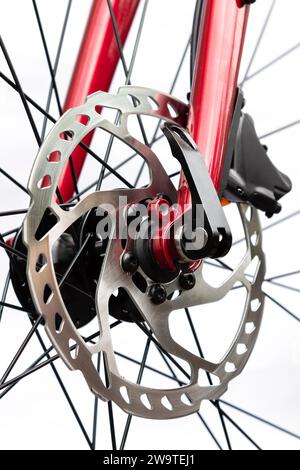 Hydraulisches Bremssystem eines Fahrrades. Nahaufnahme einer Bremsscheibe mit Bremssattel auf rotem Fahrrad auf weißem Hintergrund Stockfoto