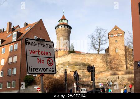 Zweisprachiges Hinweisschild für das Feuerwerksverbot in der Nürnberger Altstadt während der Silvesternacht in Deutsch und Englisch und dem Symbol mit durchgestricheneer Rakete und Böller. Hier am Burgberg vor der Kaiserburg. *** Zweisprachiges Schild für das Feuerwerkverbot in der Nürnberger Altstadt zu Silvester in deutscher und englischer Sprache und das Symbol mit durchgestrichener Rakete und Feuerwerkskörpern hier auf dem Burgberg vor der Kaiserburg 20231230-6V2A6976 Stockfoto