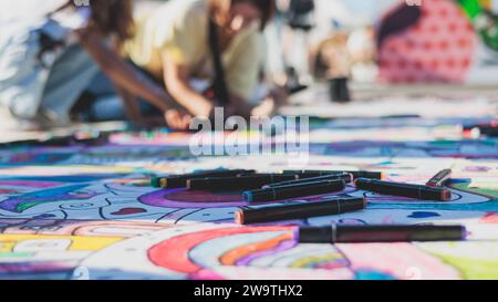 Zeichnen auf Asphalt und Pflaster, Kinder und Kinder mit Buntstiften, Kreide und Markierungen, Teenager kreieren Street Art am Boden, Graffiti und p Stockfoto