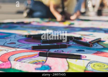 Zeichnen auf Asphalt und Pflaster, Kinder und Kinder mit Buntstiften, Kreide und Markierungen, Teenager kreieren Street Art am Boden, Graffiti und p Stockfoto