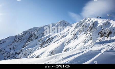 Blick auf die schneebedeckten Hügel der Niederen Tatra - Jasna und die Seilbahn, die Skifahrer zum Chopok Berg bringt. Stockfoto