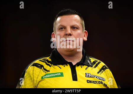 Dave Chisnall im Kampf gegen Daryl Gurney (nicht abgebildet) am 13. Tag der Paddy Power World Darts Championship im Alexandra Palace, London. Bilddatum: Samstag, 30. Dezember 2023. Stockfoto