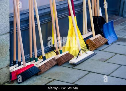 Besenbürsten und Schneespaten zum Verkauf außerhalb des Bauwarengeschäfts Stockfoto