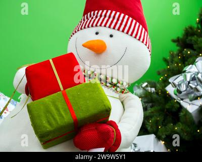 Schneemann hält in Händen Kästen mit Geschenken Stockfoto