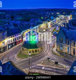 Blick in die Abenddämmerung auf Barnard Castle zur Weihnachtszeit mit Weihnachtslichtern und Dekoration mit Blick über das Market Cross und entlang der A67 Main Street Stockfoto