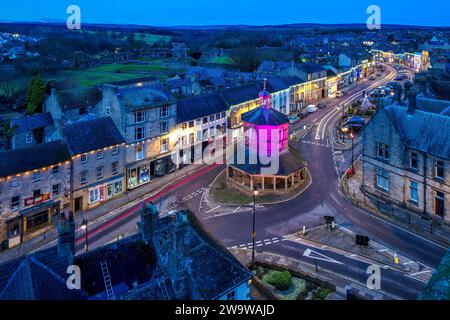 Blick in die Abenddämmerung auf Barnard Castle zur Weihnachtszeit mit Weihnachtslichtern und Dekoration mit Blick über das Market Cross und entlang der A67 Main Street Stockfoto