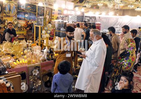 Besucher werden an den Ständen der Möbelausstellung in Hyderabad am Samstag, den 30. Dezember 2023, interessiert. Stockfoto