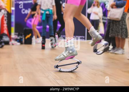 Kangoo-Schuhe, Fitness-Jumping-Training, Gruppe von jungen Frauen in Sportbekleidung auf kangoo-Sprüngen, Mädchen trainieren mit Trainer-Trainer, Sport in Th Stockfoto