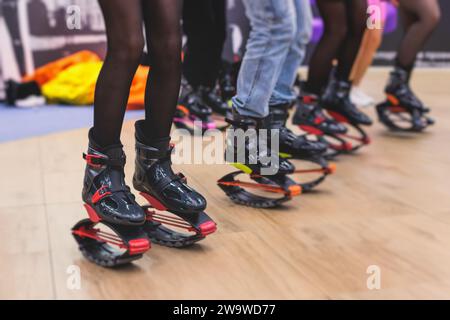 Kangoo-Schuhe, Fitness-Jumping-Training, Gruppe von jungen Frauen in Sportbekleidung auf kangoo-Sprüngen, Mädchen trainieren mit Trainer-Trainer, Sport in Th Stockfoto