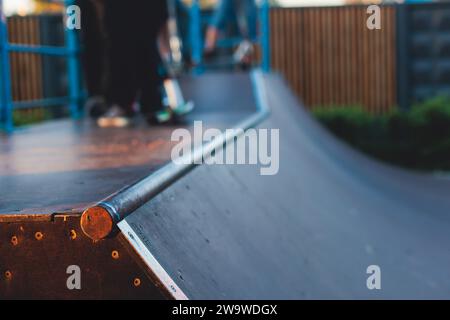 Skatepark mit Kindern auf einem Kick Scooter, die Tricks und Stunts machen, Jungs in einem Skatepark, die bmx-Fahrrad fahren und Skaten fahren, spielen und den Sommer auf dem neuen Widder genießen Stockfoto