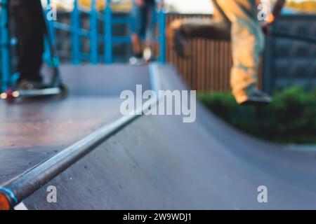 Skatepark mit Kindern auf einem Kick Scooter, die Tricks und Stunts machen, Jungs in einem Skatepark, die bmx-Fahrrad fahren und Skaten fahren, spielen und den Sommer auf dem neuen Widder genießen Stockfoto