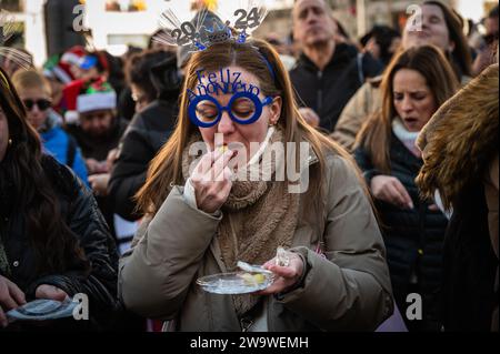 Madrid, Spanien. Dezember 2023 30. In der Puerta del Sol treffen sich Menschen, um die traditionellen 12 Trauben in einer festlichen Probe zu feiern und zu essen, die als „Pre uvas“ bekannt ist, bevor das neue Jahr 2024 beginnt. Quelle: Marcos del Mazo/Alamy Live News Stockfoto