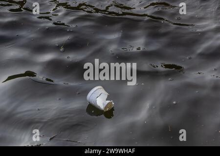 Victoria Embankment, London, UK - 13. März 2014: Ein kaputter Polystyrolbecher, der auf der Themse schwimmt. Stockfoto