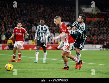 Nicolas Dominguez (links) von Nottingham Forest und Bruno Fernandes von Manchester United kämpfen um den Ball während des Premier League-Spiels auf dem City Ground in Nottingham. Bilddatum: Samstag, 30. Dezember 2023. Stockfoto