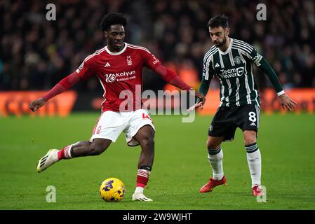 Ola Aina von Nottingham Forest (links) und Bruno Fernandes von Manchester United kämpfen um den Ball während des Premier League-Spiels auf dem City Ground in Nottingham. Bilddatum: Samstag, 30. Dezember 2023. Stockfoto