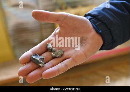 Nicht exklusiv: LEMBERG, UKRAINE - 29. DEZEMBER 2023 - Ein Mann hält Fragmente einer russischen Rakete in der Hand, Lemberg, Westukraine Stockfoto