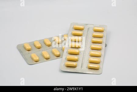 Medizinische gelbe Tabletten in Blisterpackung gegen weiß Stockfoto