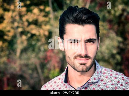 Eine Nahaufnahme eines jungen attraktiven Mannes, der ein Hemd trägt und in die Kamera schaut. Kopfschuss Stockfoto