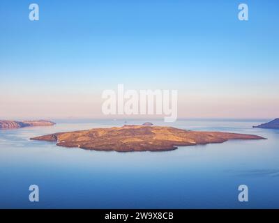 Nea Kameni Vulkan und die Caldera von Fira bei Sonnenaufgang, Santorin oder Thira Island, Kykladen, Griechenland Stockfoto