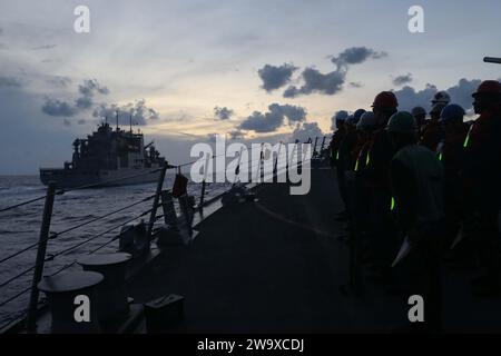 231220-N-AL206-1048 MITTELMEER (20. Dezember 2023) Seeleute des Lenkraketenzerstörers der Arleigh-Burke-Klasse USS Thomas Hudner (DDG 116) stehen bereit, als Thomas Hudner sich dem Trockenfrachtschiff der Lewis-Clark-Klasse USNS William McLean (T-AKE 12) nähert, um auf See am 20. Dezember 2023 eine Wiederauffüllung auf See zu machen. Thomas Hudner ist Teil der Gerald R. Ford Carrier Strike Group und arbeitet derzeit im US-Einsatzgebiet 6th Fleet unter der Leitung des Verteidigungsministers. Die USA halten nach vorne entsandte, bereitwillige und positionierte Kräfte bereit, um Agg abzuschrecken Stockfoto