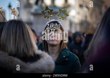 Madrid, Spanien. Dezember 2023 30. Eine Frau trägt mit dem Jahr 2024 eine Partybrille, während sie die Ankunft eines neuen Jahres auf der Plaza de la Puerta del Sol feiert. Wie jedes Jahr im Dezember 30 haben Hunderte von Menschen den Beginn des neuen Jahres im Voraus gefeiert. In Madrid haben Familien und Freunde traditionell Silvestertrauben getrunken. (Credit Image: © David Canales/SOPA Images via ZUMA Press Wire) NUR REDAKTIONELLE VERWENDUNG! Nicht für kommerzielle ZWECKE! Stockfoto