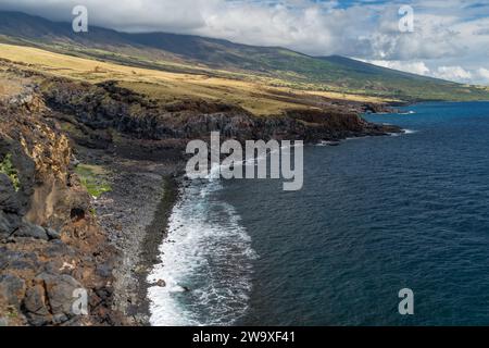 Lavasteilküsten überragen das tiefblaue Wasser von Maui und zeigen die dynamische vulkanische Landschaft der Insel. Stockfoto