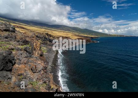 Lavasteilküsten überragen das tiefblaue Wasser von Maui und zeigen die dynamische vulkanische Landschaft der Insel. Stockfoto