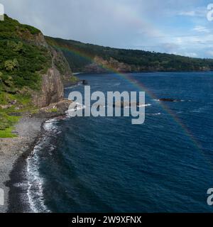 Dieser abgeschiedene schwarze Sandstrand, umgeben von üppigem tropischem Grün und Lavasteinen, ist ein ruhiger Ort an Mauis Südküste in der Nähe des Piilani Highway. Stockfoto