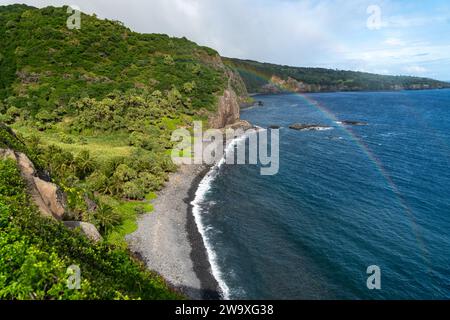 Dieser abgeschiedene schwarze Sandstrand, umgeben von üppigem tropischem Grün und Lavasteinen, ist ein ruhiger Ort an Mauis Südküste in der Nähe des Piilani Highway. Stockfoto