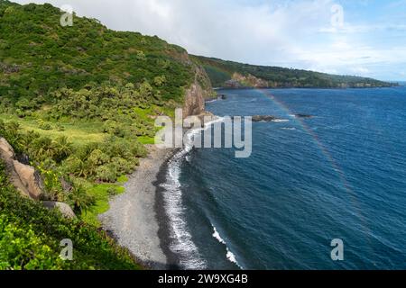 Dieser abgeschiedene schwarze Sandstrand, umgeben von üppigem tropischem Grün und Lavasteinen, ist ein ruhiger Ort an Mauis Südküste in der Nähe des Piilani Highway. Stockfoto