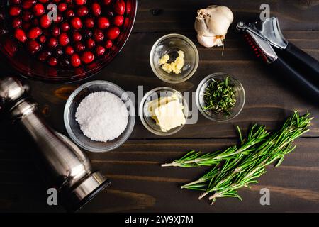 One Pan Rosmarin Hähnchenschenkel mit Cranberry Sauce vorbereitete Zutaten: Gehackter Rosmarin, gehackter Knoblauch und andere abgemessene Speisen in Zubereitungsschüsseln Stockfoto