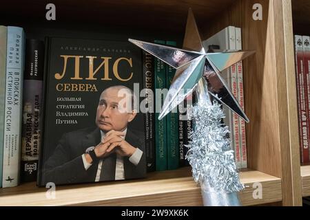 St. Petersburg, Russland. Dezember 2023 30. Vater Frosts Neujahrsstab steht neben einem Buch über den russischen Präsidenten Wladimir Putin, „der Fuchs des Nordens“, im Buchladen „Haus des Buches“ in St. Petersburg während eines interaktiven Neujahrsprogramms für Stadtbewohner. Quelle: SOPA Images Limited/Alamy Live News Stockfoto