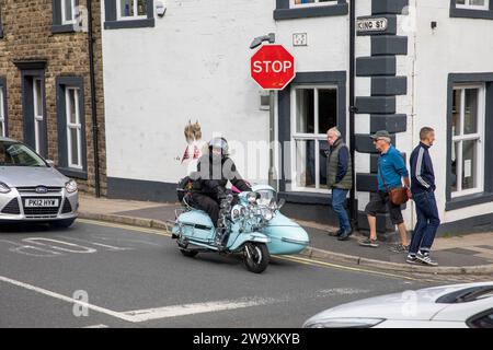 Mann und Frau auf Roller mit Beiwagen im Stadtzentrum von Clitheroe, Lancashire, während der Motorroller-Rallye 2023 im Stadtzentrum von England, Großbritannien Stockfoto