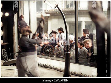 1934 v. Chr., Paris , FRANKREICH : Familiengruppen mit Kindern, vor einem Spielzeugfenster ( mit mechanischen Puppen von Feuerwehrleuten in Bewegung ), während der Weihnachtszeit , die Geschenke des Weihnachtsmanns träumen . Die Eröffnung dieser Spezialfenster im dezember markiert traditionell den Beginn der Weihnachtszeit . Foto von Agencie Meurisse , unbekannter Fotograf . DIGITAL COLORIERT. - WEIHNACHTEN - GIOCO - FREUDE - GIOIA - ÜBERRASCHUNG - SORPRESA - STUPORE - ERSTAUNLICH - GIOCATTOLI MECCANICI IN MOVIMENTO - SPIELZEUG - VETRINA DI UN NEGOZIO - WEIHNACHTEN - IMMAGINE NATALIZIA - FOTO STORICHE - GESCHICHTE - BAM Stockfoto