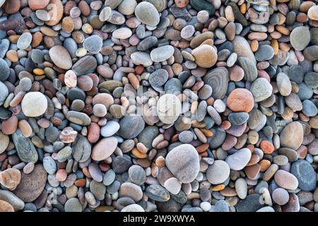 Lächelnde Kieselsteine auf mattierten Kieselsteinen am Strand. Morayshire, Schottland Stockfoto