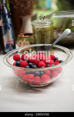 Gemischte Himbeeren und Heidelbeeren in einer Schüssel auf einer Küchenbank Stockfoto