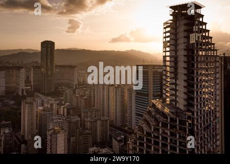 Caracas, Venezuela. Dezember 2023. (ANMERKUNG DER REDAKTION: Bild von einer Drohne) der David Tower ist bei Sonnenuntergang aus nächster Nähe zu sehen. Der Wolkenkratzer sollte zum Symbol des Reichtums und Fortschritts Venezuelas werden, wurde aber in den 90er Jahren unvollendet gelassen und jahrelang von obdachlosen Familien besetzt, bis sie 2014 vertrieben wurden. (Foto: Davide Bonaldo/SOPA Images/SIPA USA) Credit: SIPA USA/Alamy Live News Stockfoto