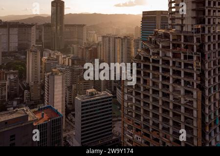 Caracas, Venezuela. Dezember 2023. (ANMERKUNG DER REDAKTION: Bild von einer Drohne) der David Tower ist bei Sonnenuntergang aus nächster Nähe zu sehen. Der Wolkenkratzer sollte zum Symbol des Reichtums und Fortschritts Venezuelas werden, wurde aber in den 90er Jahren unvollendet gelassen und jahrelang von obdachlosen Familien besetzt, bis sie 2014 vertrieben wurden. (Foto: Davide Bonaldo/SOPA Images/SIPA USA) Credit: SIPA USA/Alamy Live News Stockfoto