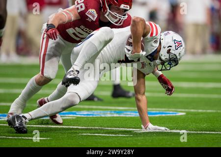 San Antonio, TX, USA. Dezember 2023. Der Arizona Wildcats Wide Receiver Tetairoa McMillan (4) versucht, aufrecht zu bleiben, nachdem er während des Valero Alamo Bowl NCAA-Fußballspiels zwischen den Arizona Wildcats und den Oklahoma Sooners in San Antonio (Texas) einen Fang gemacht hat. Trask Smith/CSM/Alamy Live News Stockfoto