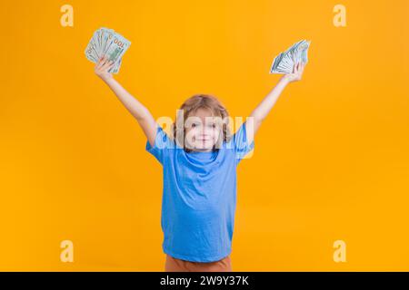 Der Junge hat viele hundert Dollar isoliert auf gelbem Hintergrund. Stockfoto
