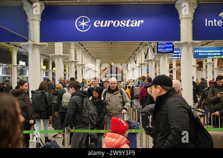 Passagiere stehen am Eingang zum Eurostar in der St Pancras International Station im Zentrum von London an. Eurostar hat angekündigt, dass alle seine Dienste am Sonntag wieder aufgenommen werden, nachdem die Überschwemmungen in Tunneln unter der Themse unter Kontrolle gebracht wurden, obwohl Geschwindigkeitsbeschränkungen zu Verzögerungen führen können. Bilddatum: Sonntag, 31. Dezember 2023. Stockfoto