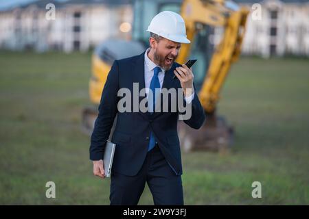 Buider-Mann in Anzug und Schutzhelm. Bauinvestor. Geschäftsmann-Investor vor der Baustelle. Erfolgreicher Investor. Ein hübscher Mann im Anzug Stockfoto